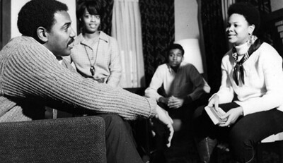 Photo of 2 people sitting on couches, with Jerry Durley, CHANCE administrator, with NIU during the program orientation seemingly on the person in focus. 
